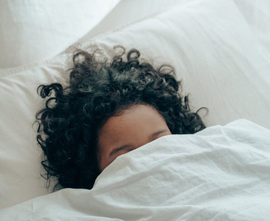 unrecognizable person sleeping under blanket